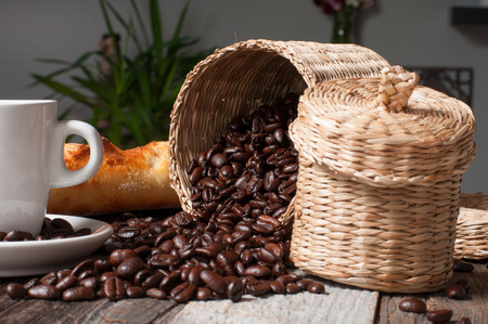 Coffee beans and bread on wood tableの写真素材