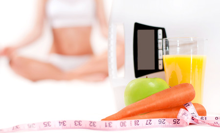 Diet concept. Slim woman. Weight scale with glass of orange juice and health foodの写真素材