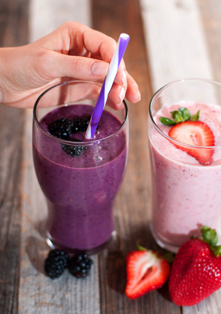 Healthy Eating. Berry smoothies, milkshakes made with fresh blueberries and strawberries in a glassの写真素材
