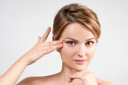 Beauty and facial treatment. Beautiful woman with clean perfect skin touch own face.の写真素材