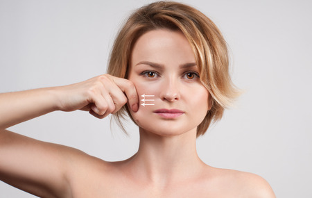 Beauty and facial treatment. Beautiful woman with clean perfect skin touch own face.の写真素材