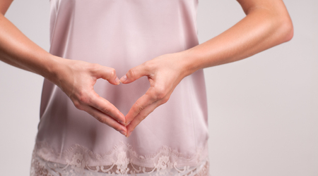 Woman showing heart shape on her fingersの写真素材