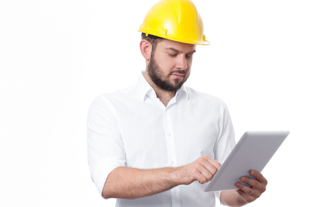 Contractor in yellow helmet working on a project with tablet. Business man in builder helmet.の写真素材