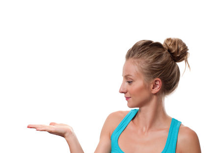 Woman showing a product - empty copy space on the open hand palm. Young woman is holding open palm and looking at her handの写真素材