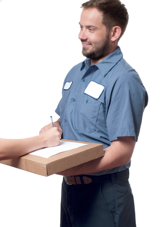 Delivery man holding a parcel while woman putting signature in clipboar.  Courier service conceptの写真素材