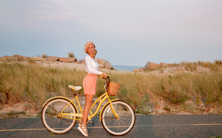 Beatiful woman with bike on the beach. Summer vacationの写真素材