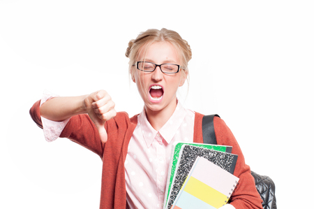 Annoyed young student girl holding books, standing isolated on white background. Back to schoolの写真素材