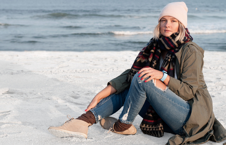 Beautiful woman sitting on lonely beachの写真素材