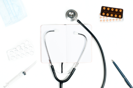 Medical stethoscope. Workplace of doctor - stethoscope, medical items and pills on deskの写真素材