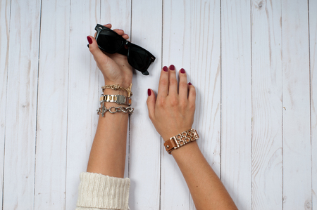 Female hands with jewelry and sunglasses. Fashion accessories, wrist watches, glamor bracelets and ringsの写真素材