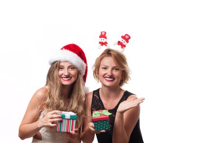 Christmas. Winter Holiday. Beautiful girls wear santa hat with christmas giftの写真素材