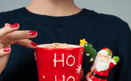  Christmas and happy holiday concept. Woman in warm sweater is holding a cup of coffee. の写真素材