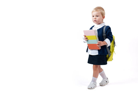 Happy little schoolgirl. Child with backpack and books. Preschool go to school. 