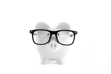 Front view. White piggy bank in glasses isolated on whiteの写真素材