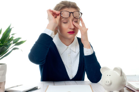 Exhausted businesswoman working at office desk is having an headache, too much workの写真素材