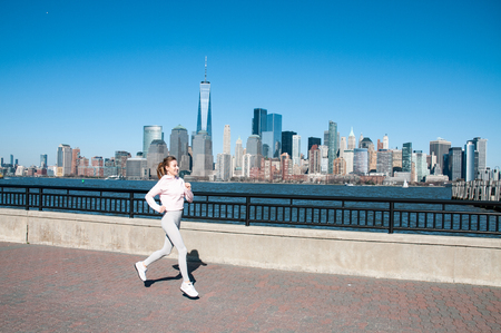 Healthy lifestyle. Woman is running in New York City. Fitness sports runner is jogging in Liberty State Park の写真素材