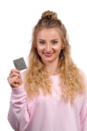 Beautiful young woman is holding a condom の写真素材