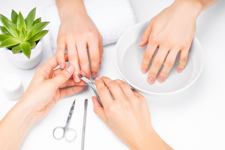 Hands care in the spa. Beautiful woman's hands with perfect manicure. Manicurist master makes manicureの写真素材