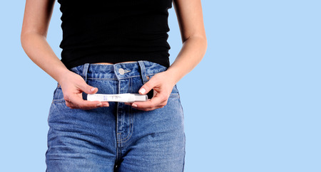 Pregnant test. Woman holdinj a positive pregnancy testの写真素材