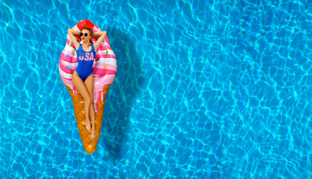 Summer Vacation. Enjoying suntan Woman in bikini on the inflatable mattress in the swimming pool.の写真素材