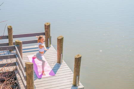 Yoga. Young woman practicing yoga Warrior pose. Concept of calm and meditation.の写真素材