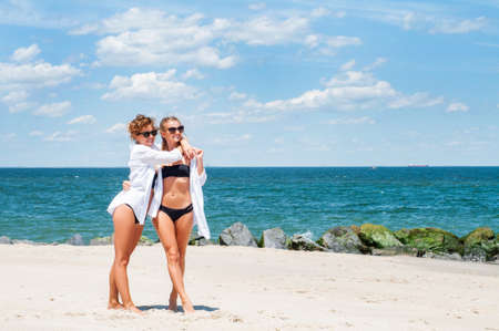 Happiness moment. Two Attractive women in bikini on the beach. Best friends having fun, summer vacation holiday lifestyle.の写真素材