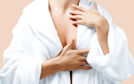 Body care concept. Beautiful woman after bath in white bathrobe on pastel background.の写真素材