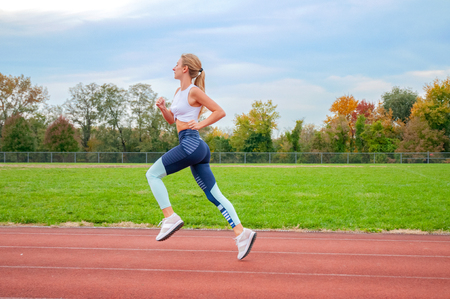 Healthy lifestyle young fitness woman running. Female runner practicing on running laneの写真素材
