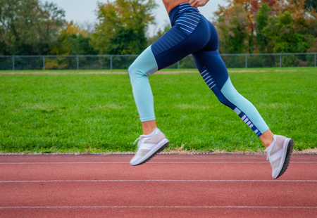 Healthy lifestyle. Athletic woman running on athletics race track.の写真素材
