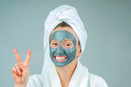 Spa Clay Mask. Beautiful young woman with clay facial mask. Skincare and beauty Concept.の写真素材