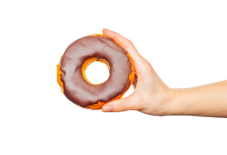 Female hand holding donut. Colorful donut on pastel white background