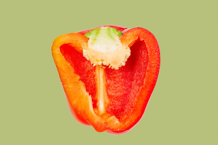 Half red bell pepper levitate in air on green pastel background. の写真素材