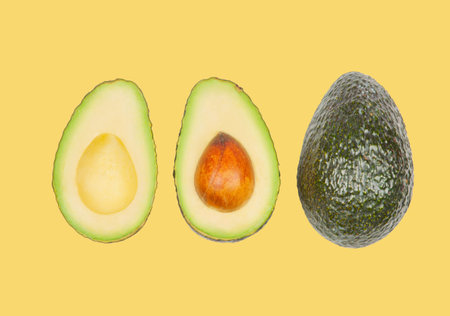 Half avocados levitate in air on yellow pastel background. Concept of vegetable levitation.