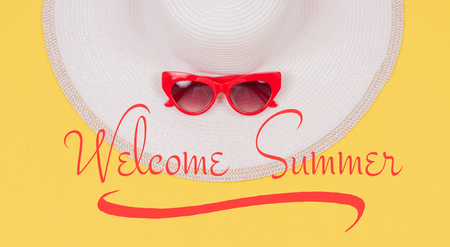 Welcome Summer text on yellow background, summer hat and sunglasses. Beach accessoriesの写真素材