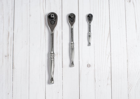Tools, socket wrenches on a white wooden background. Top view