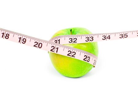Dieting and Healthy lifestyle concept. Fresh green apple and measuring tape on white background.の写真素材