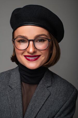 Beautiful business woman brunette in black beret and eyeglasses. Checking new eyeglassesの写真素材