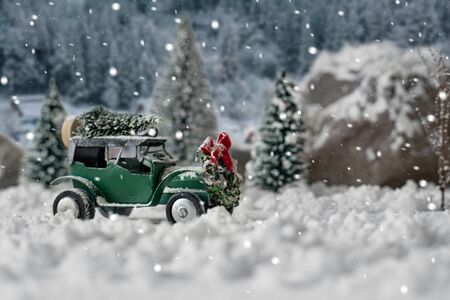 Miniature classic car carrying a christmas tree on snowy winter magic landscapeの写真素材