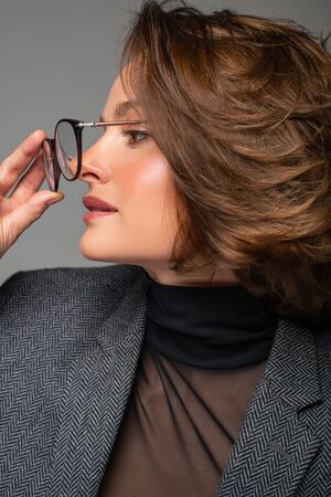 Beautiful business woman brunette with bob haircut in eyeglasses. Checking new eyeglassesの写真素材