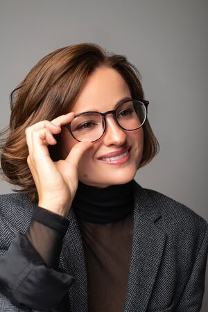 Beautiful business woman brunette with bob haircut in eyeglasses. Checking new eyeglassesの写真素材