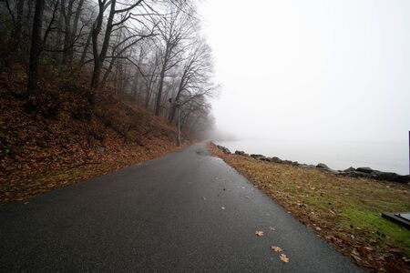 Autumn landscape. Morning fog by the river. Road along the river.の写真素材