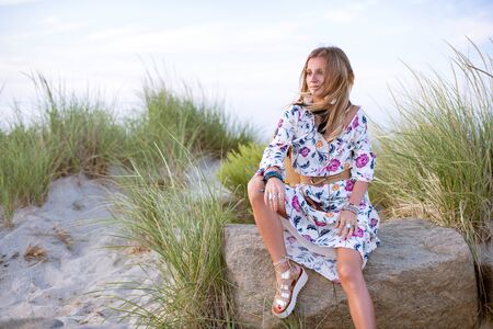 Beautiful woman wearing long dress and accessories boho style. Attractive bohemian style girl on the beachの写真素材