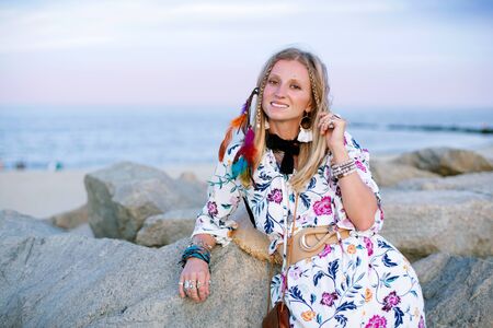 Beautiful woman wearing long dress and accessories boho style. Attractive bohemian style girl on the beachの写真素材