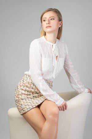 Fashionable clothes. Beautiful fashion woman in skirt and a white shirt in studioの写真素材