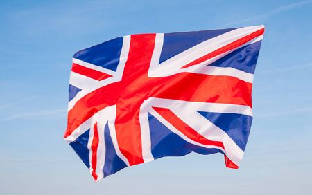 National Flag of United kingdom. British flag on blue sky background.の写真素材
