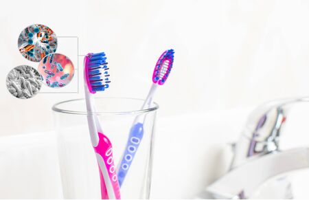 Dental hygiene. Tooth brushes with bacteria in glass in the bathroomの写真素材
