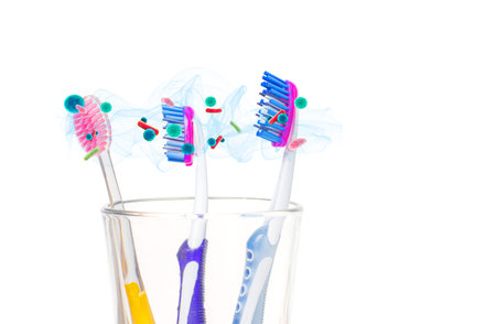 Dental hygiene. Tooth brushes with bacteria in glass on white background