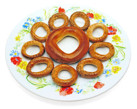 A bagel and drying on a plate, the symbolical image of a flower. Object on a white background.                の写真素材