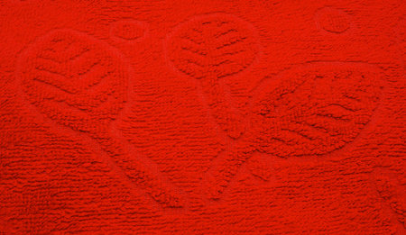 An image of leaves is in relief texture of fabric, decorative red background.               の写真素材