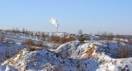 Winter landscape, relief from hills and ravines, light, blue, cold sky. White smoke from the pipe of the thermal electric station. の写真素材
